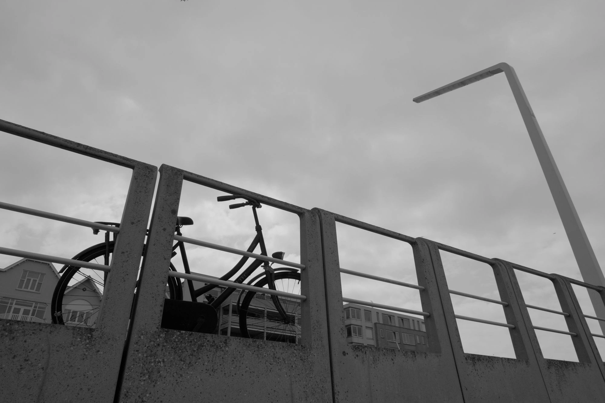 2026-07-18 - xt15-45 - bw - NL - Scheveningen - Bike parked next to fence