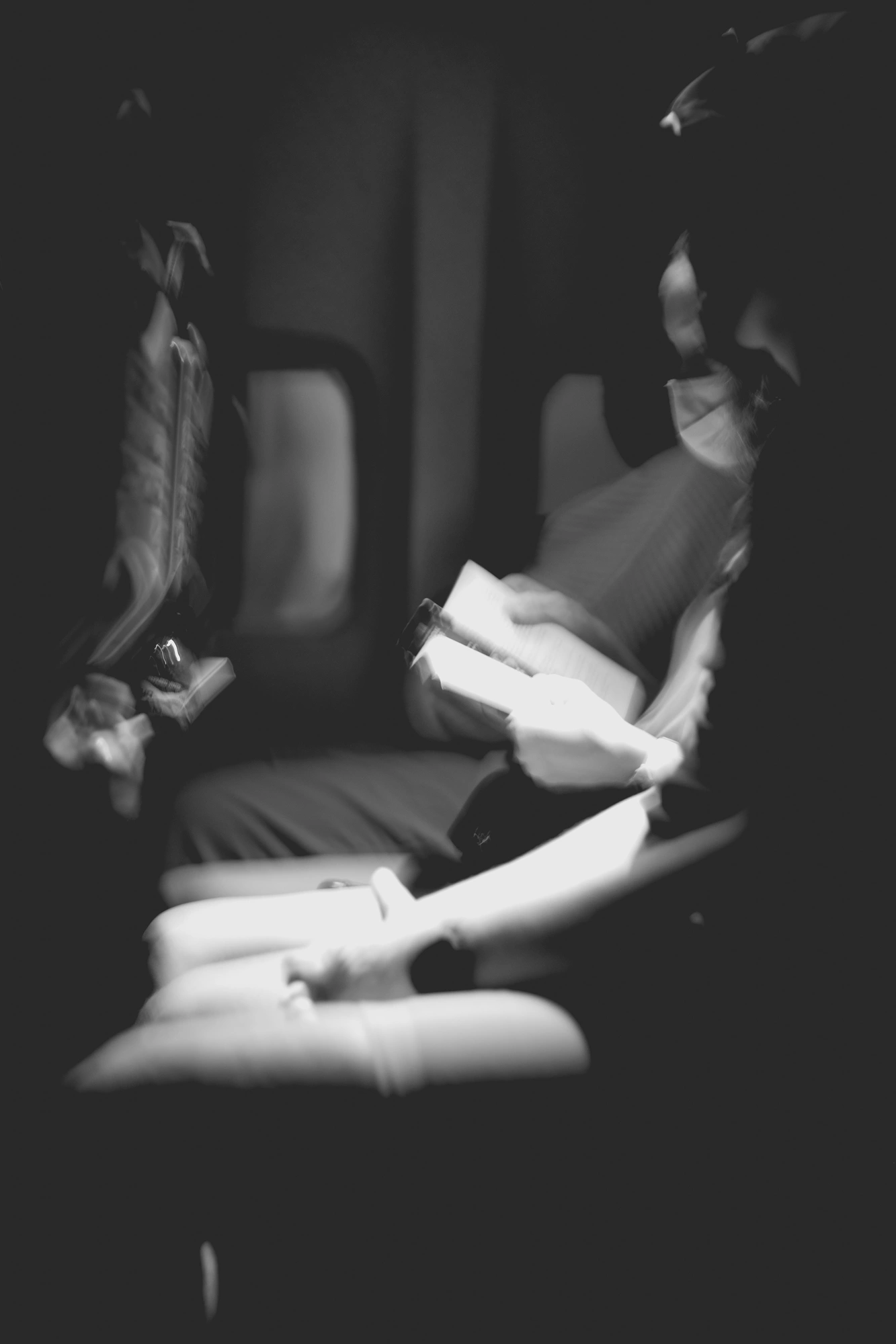 2022-02-18 - xt35 - bw - ZA - Cape Town - Person reads book in the dark on airplane