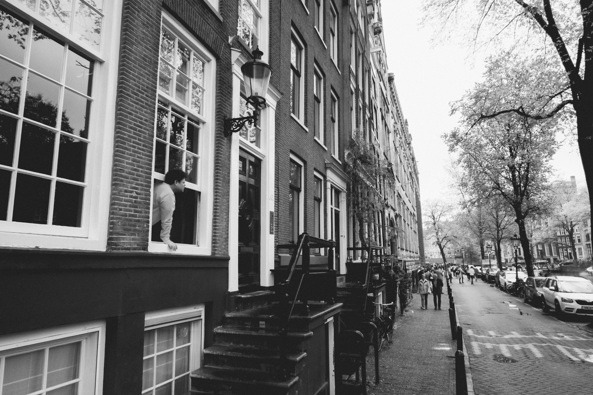 2024-04-26 - xt15-45 - bw - NL - Amsterdam - Person sticking head out of window